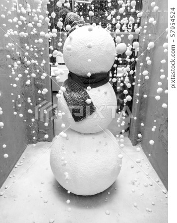 Closeup image of snowman in the black sharf on the Christmas shop wind Closeup image of snowman in the black sharf on the Christmas shop wind 57954524