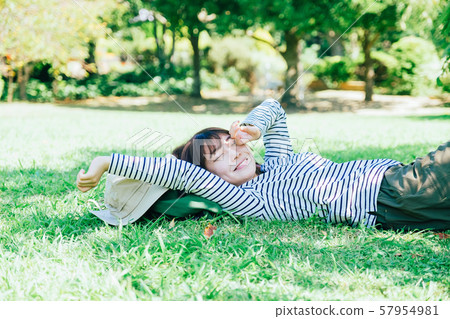 A woman lying down on the lawn 57954981