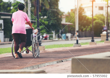 Senior couple with wheelchair in city Senior couple with wheelchair in city 57955002