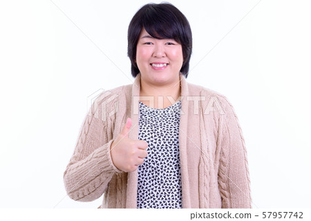 Happy overweight Asian woman giving thumbs up for winter Happy overweight Asian woman giving thumbs up for winter 57957742