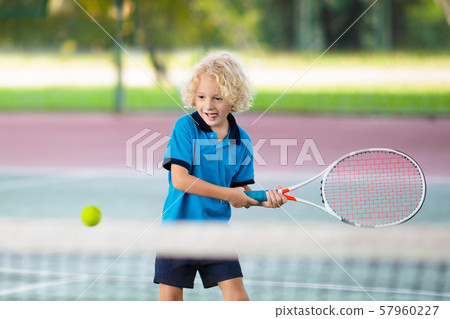 Child playing tennis on outdoor court Child playing tennis on outdoor court 57960227