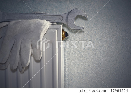 Man is repairing radiator battery in the room. Man is repairing radiator battery in the room. 57961304