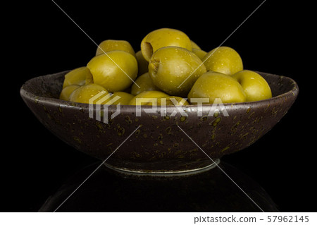 Pitted green olive isolated on black glass 57962145