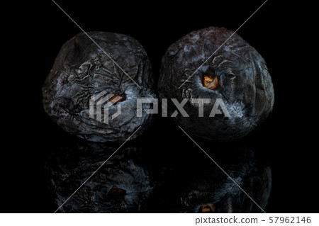 Drying dark plum isolated on black glass Drying dark plum isolated on black glass 57962146