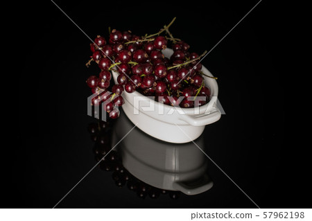 Fresh dark redcurrant isolated on black glass 57962198