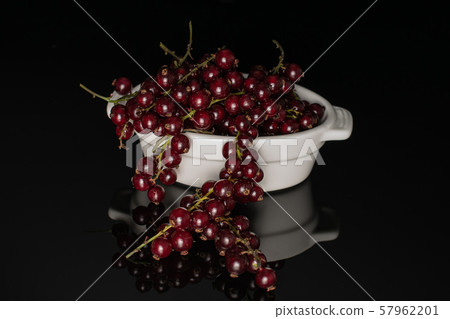Fresh dark redcurrant isolated on black glass 57962201