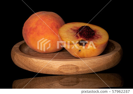Fresh fuzzy peach isolated on black glass Fresh fuzzy peach isolated on black glass 57962287