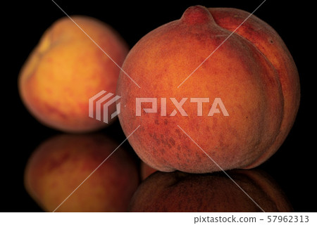 Fresh fuzzy peach isolated on black glass Fresh fuzzy peach isolated on black glass 57962313
