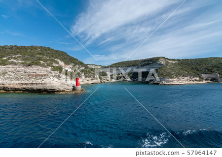 View from the yacht to the lighthouse, rocks. Blue sky with small clouds 57964147