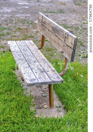 Wooden bench painted white on a grassy terrain 57964796