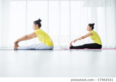 Two young Asian women workout practicing yoga in Two young Asian women workout practicing yoga in 57968581