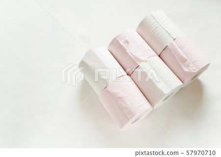 New white and pink toilet paper that is laid down so that the glued portion can be seen in two rows of three rolls on a white background 57970710