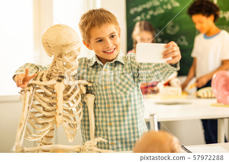 Handsome blonde boy looking at his smartphone 57972288