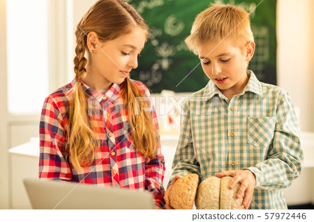 Attentive longhaired girl looking at lesson equipment Attentive longhaired girl looking at lesson equipment 57972446