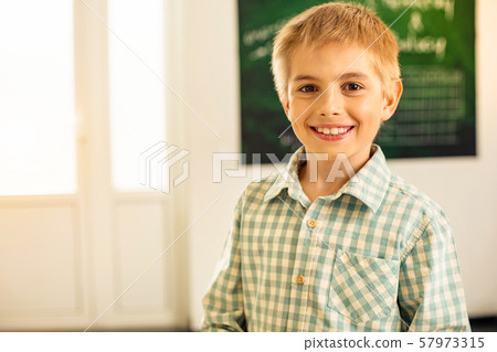 Joyful blonde schoolboy demonstrating his sincere emotions Joyful blonde schoolboy demonstrating his sincere emotions 57973315