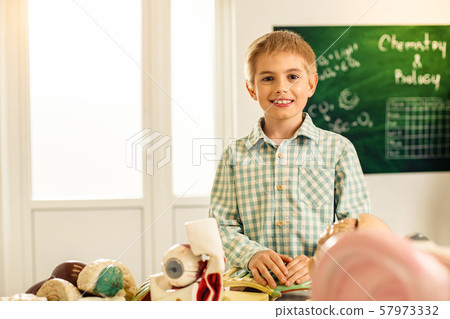 Positive delighted boy looking straight at camera Positive delighted boy looking straight at camera 57973332
