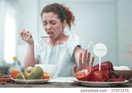 Curly woman having skin rash because of red vegetables Curly woman having skin rash because of red vegetables 57973378