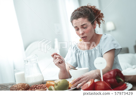 Young curly woman with skin rash having strong allergy to gluten Young curly woman with skin rash having strong allergy to gluten 57973429
