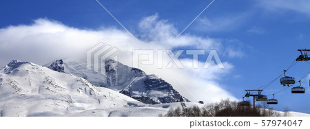 Ski-lift, off-piste slope and mountain in clouds 57974047