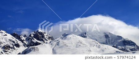 Mountains in clouds and off-piste slope in winter Mountains in clouds and off-piste slope in winter 57974124
