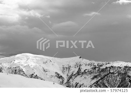 Sunlight snowy mountains and cloudy gray sky in Sunlight snowy mountains and cloudy gray sky in 57974125