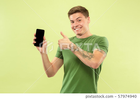 Caucasian young man's half-length portrait on green background 57974940
