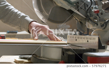 Carpenter cutting a plank with circular saw Carpenter cutting a plank with circular saw 57976271