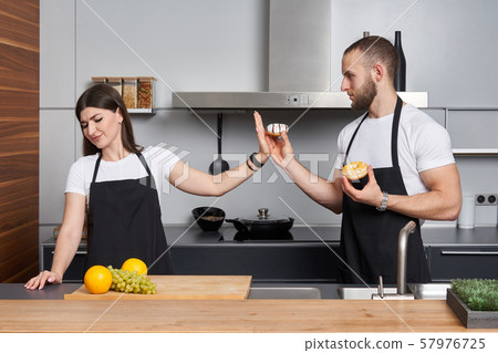 Young family in the kitchen with vegetables Young family in the kitchen with vegetables 57976725