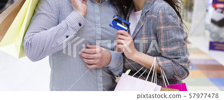 Easy shopping. Couple with credit card and paper bags Easy shopping. Couple with credit card and paper bags 57977478