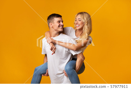 Young guy giving piggyback ride to his girlfriend 57977911