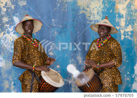 A group of people in traditional african costumes playing jembe drums 57978705
