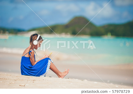 Little adorable girl listening music background sea 57978729