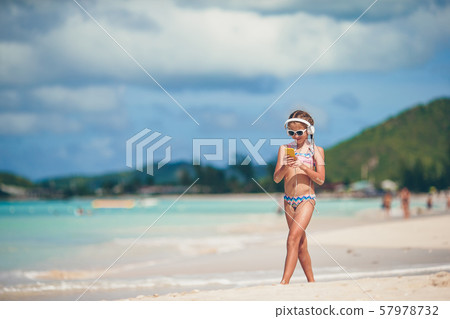Little adorable girl listening music background sea Little adorable girl listening music background sea 57978732