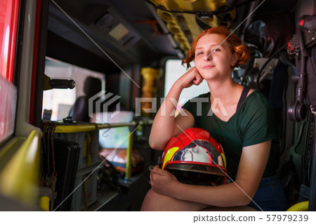 Photo of ginger woman looking in camera sitting in cab of fire engine 57979239