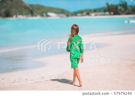 Little cute girl with seashell in hands at tropical beach. 57979240