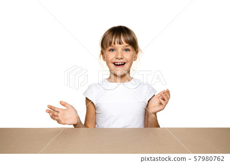 Cute little girl opening the biggest postal package Cute little girl opening the biggest postal package 57980762