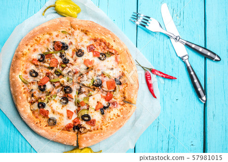 Vegetarian pizza with vegetables on blue table. 57981015