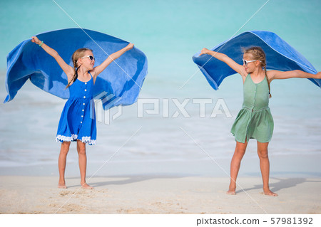Little girls having fun enjoying vacation on tropical beach 57981392
