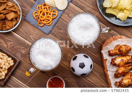 Appetizers and beer on the table for watch the football match. Appetizers and beer on the table for watch the football match. 57981435