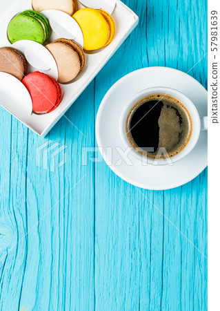 Multicolored macaroons with black coffee 57981639