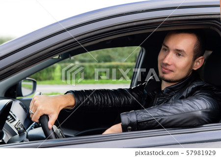 young man in a car on a city street 57981929
