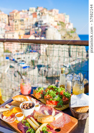 Tasty italian snack. Fresh bruschettes, cheeses and meat on the board in outdoor cafe with amazing 57982144