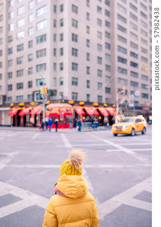 Adorable little girls have fun on Times Square in New York City 57982438