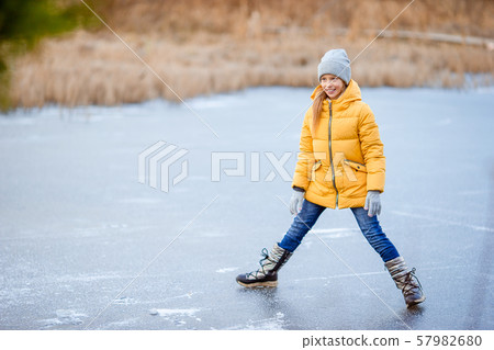 Adorable little girls skating on the ice-rink Adorable little girls skating on the ice-rink 57982680