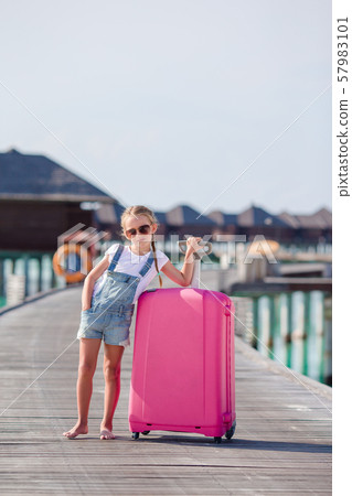 Little adorable girl with big luggage during summer vacation Little adorable girl with big luggage during summer vacation 57983101