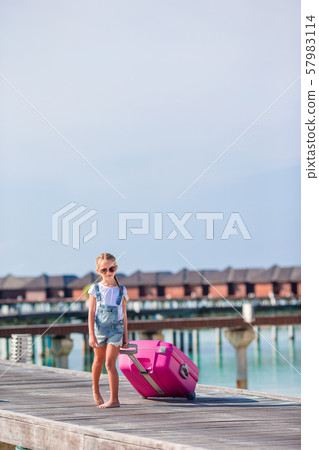 Little adorable girl with big luggage during summer vacation Little adorable girl with big luggage during summer vacation 57983114