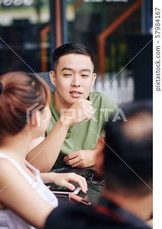 Young man with friends in cafe 57984167