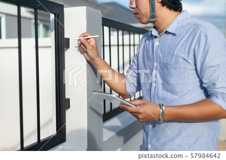 Male architect, inspecting house construction 57984642