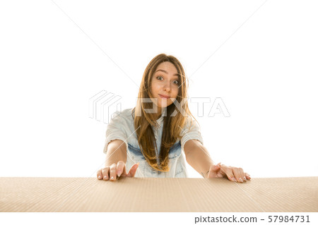 Young woman opening the biggest postal package isolated on white Young woman opening the biggest postal package isolated on white 57984731