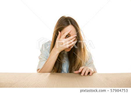 Young woman opening the biggest postal package isolated on white 57984753